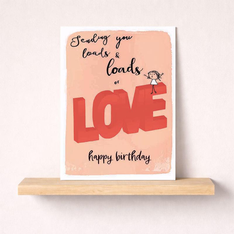 A cute cartoon girl holds a block with "love" written on it, surrounded by vibrant colors. Perfect for birthdays, this card sends warm wishes with the message "Sending you loads &amp; loads of LOVE happy birthday". Ideal for friends, family, or significant others.