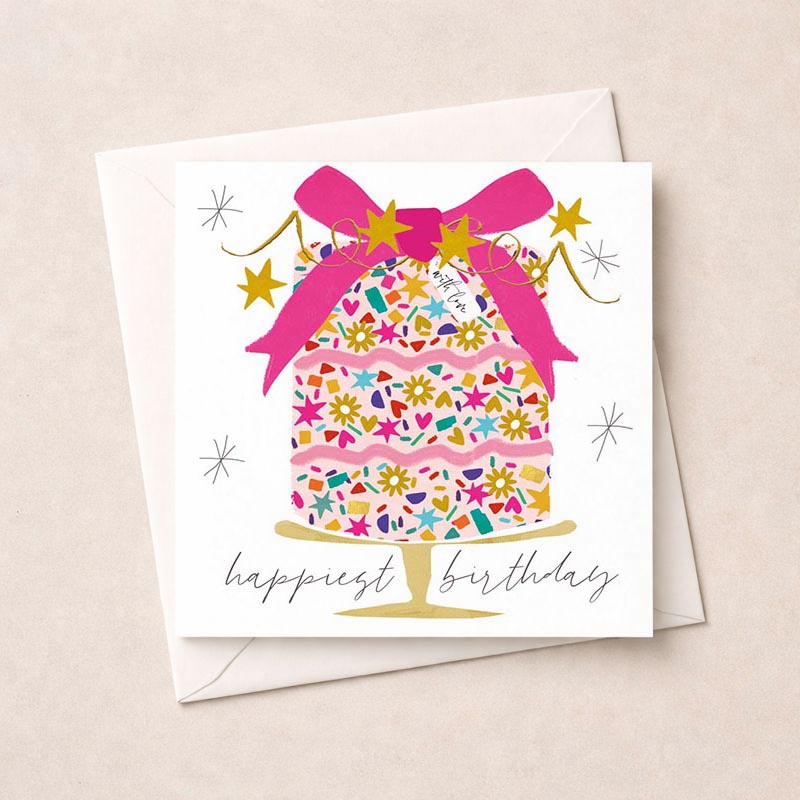 Whimsical cake with pink bow, stars, and love written in elegant script on a birthday greetings card.