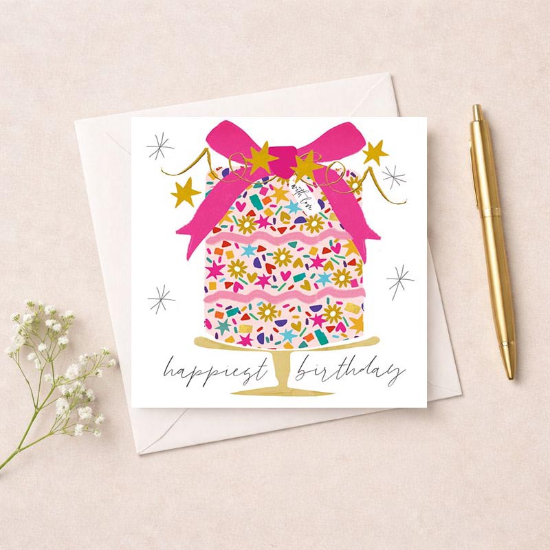 Whimsical cake with pink bow, stars, and love written in elegant script on a birthday greetings card.