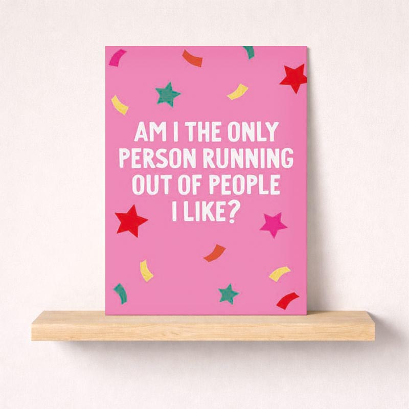 Bright pink greetings card with stars and confetti. Message reads: "AM I THE ONLY PERSON RUNNING OUT OF PEOPLE I LIKE?" Perfect for sending a humorous and honest message to a friend or loved one.